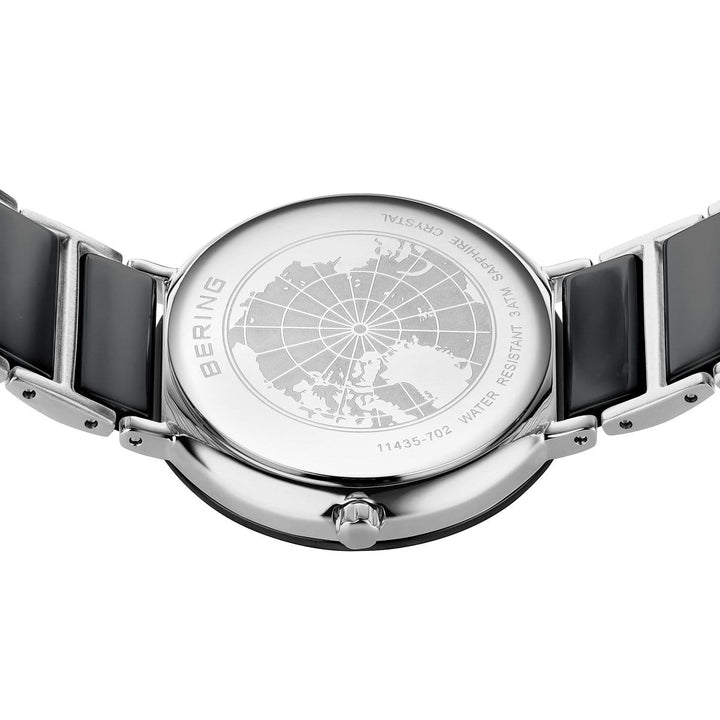 De Bering 11435-702 dameshorloge heeft een zilverkleurige kast, zwarte band, gegraveerde Arctische kaart, saffierglas, waterbestendigheid en een referentienummer - premium kenmerken van dit luxe keramische horloge.