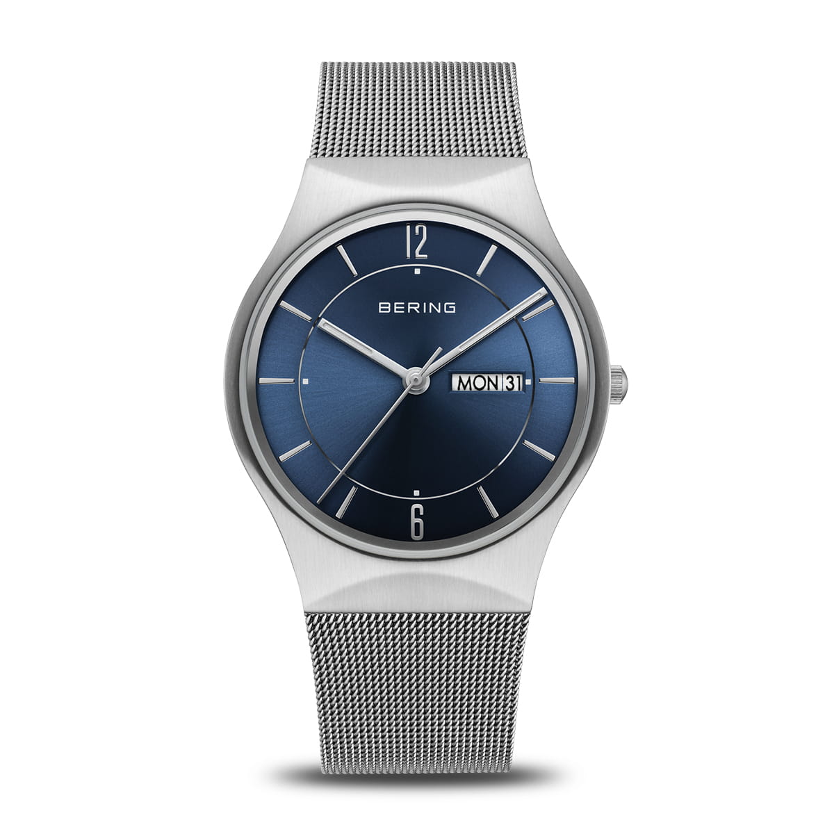 De 11938-003DD van Bering is een strak horloge met een zilveren meshband en een ronde blauwe wijzerplaat. Het heeft quartzprecisie met zilveren uurmarkeringen, wijzers, dag-/datumweergave aan de rechterkant en Bering bovenaan, allemaal beschermd door duurzaam saffierglas.