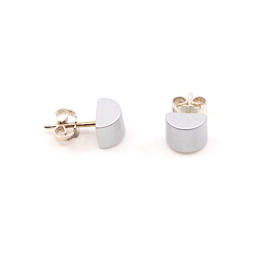 Zilveren half ronde oorbellen met een gladde, metallic afwerking.