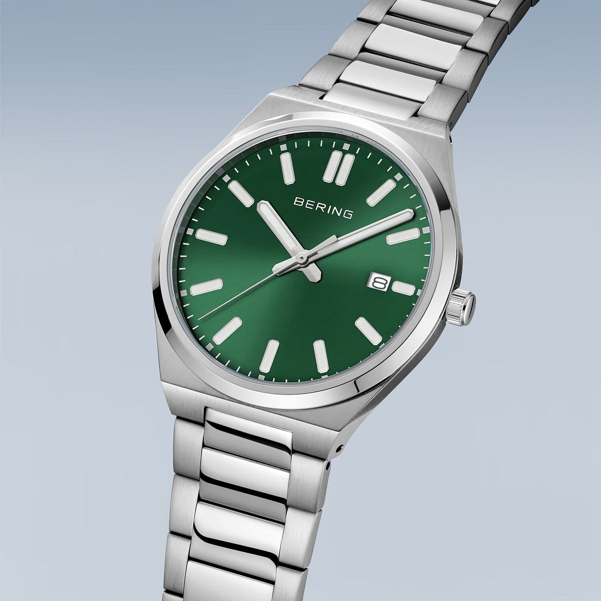 De Bering heren horloge groene wijzerplaat 17639-708 is een zilverkleurig horloge met een groene wijzerplaat, witte uurmarkeringen, datumweergave op 3 uur en BERING-logo onder 12 uur, afgebeeld schuin tegen een lichte achtergrond.