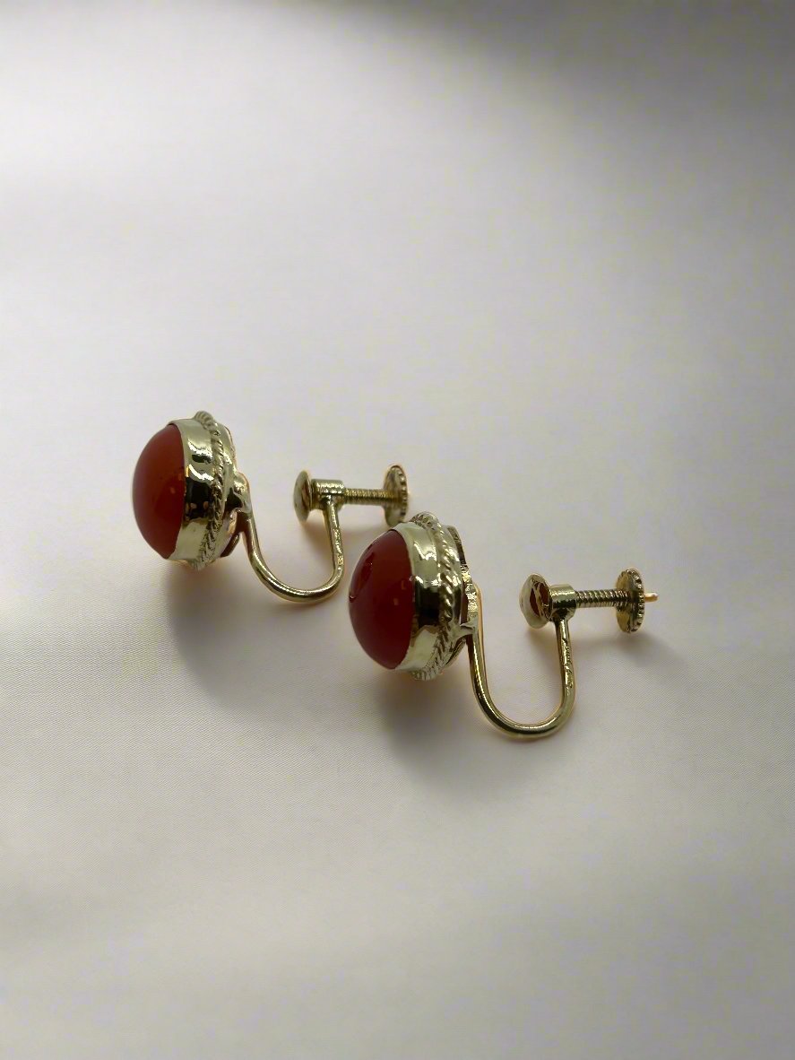 Vintage gouden oorbellen met 14k bloedkoraal, ronde schijfvorm en een gedetailleerde afwerking.