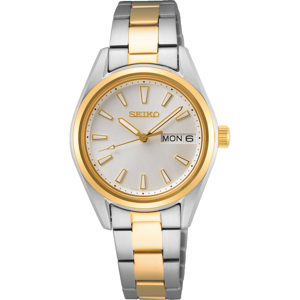 Het Seiko dameshorloge SUR454P1 heeft een ronde wijzerplaat met gouden uurmarkeringen en wijzers. Het quartz uurwerk toont Mon 6, terwijl de band zilveren en gouden schakels afwisselt, aangevuld met krasbestendig Saffierglas voor verfijning.