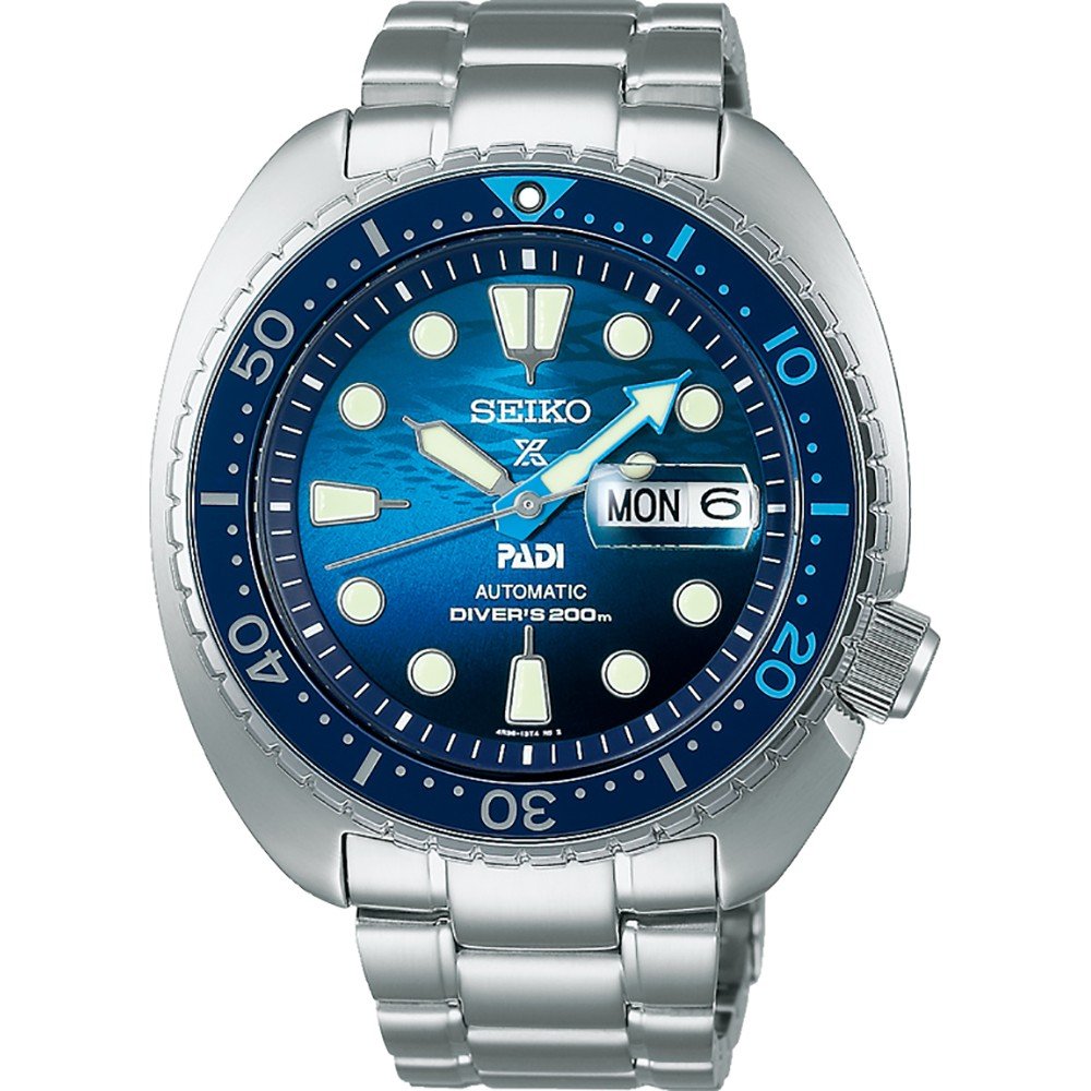 Het Seiko Prospex heren horloge SRPK01K1 is een automatisch duikhorloge met een zilverkleurige metalen band, een blauwe wijzerplaat met het PADI-logo, lichtgevende markeringen, een dag-datumaanduiding en waterbestendigheid tot 200 meter.