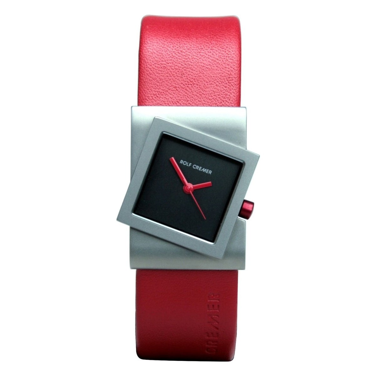 Het Rolf Cremer Horloge 491818 is een modern unisex horloge met een rode leren band, zilveren gekanteld vierkant frame, zwarte wijzerplaat met rode wijzers en markeringen, en Rolf Cremer in het wit. Het heeft een strakke titanium kast en quartz uurwerk.