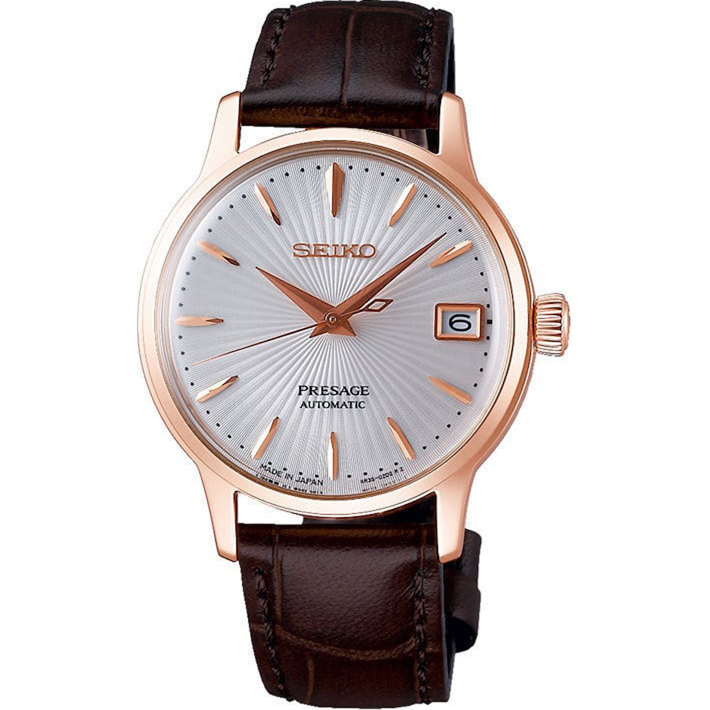 Roségouden dames horloge met een zilveren wijzerplaat, bruine leren band en datumweergave.