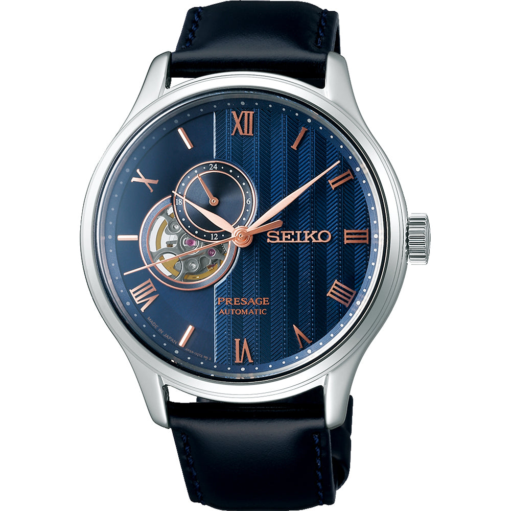 Het Seiko heren horloge SSA421J1 heeft een automatisch uurwerk, blauwe wijzerplaat, roségouden Romeinse cijfers en wijzers, open-hart mechanisme, zwart lederen band, zilverkleurige kast en saffierglas.