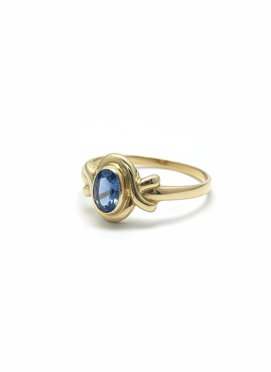 Vintage gouden ring van 14k met een ronde, blauwe topaas en een knoopdesign.