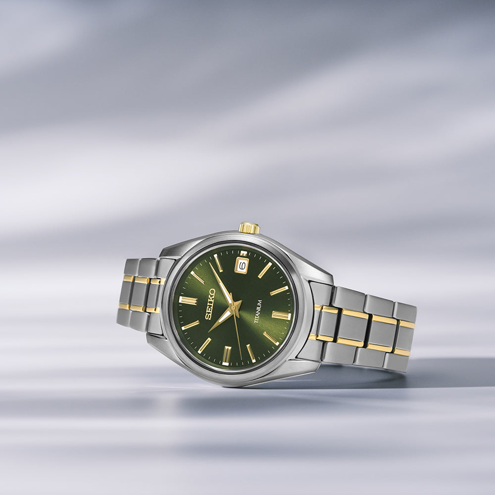 Het Seiko heren horloge SUR377P1 heeft een stralende groene wijzerplaat, een strakke zilver-gouden two-tone band en een datumvenster op 3 uur. Tegen een zacht vervaagde lichtgrijze achtergrond belichaamt dit horloge Seikos beroemde tijdloze vakmanschap.