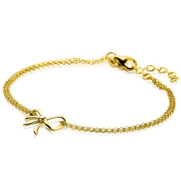 Gouden armband met een fijn schakelpand en een strik als opvallend detail.