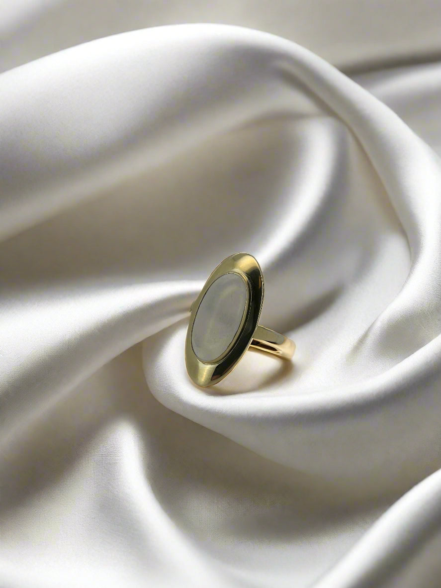 Vintage gouden ring met een ovale maansteen, 14k, op een zachte, glanzende ondergrond.