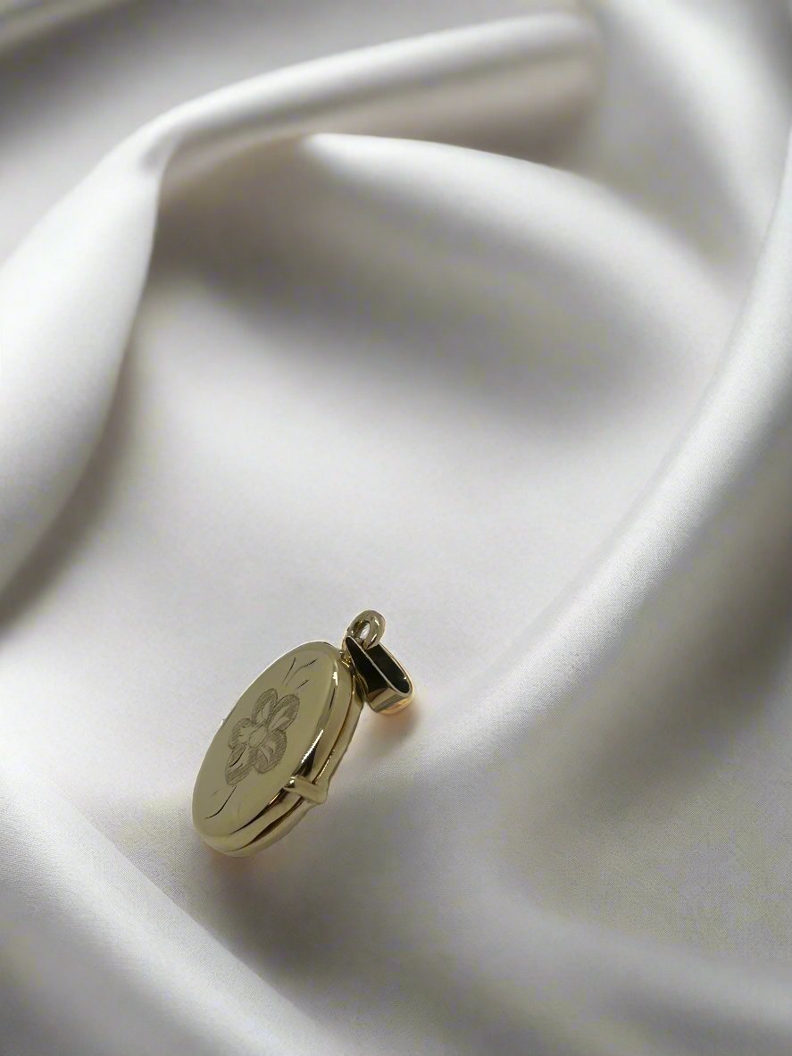 Vintage gouden medaillon van 14k met bloemmotief, glanzende afwerking en een gewicht van 3,4 gram.