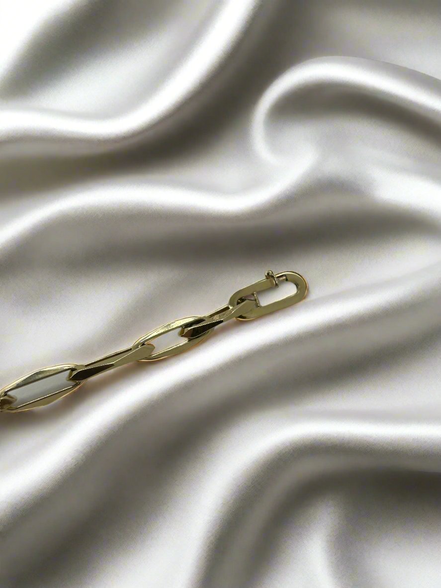 De vintage gouden armband 14k closed forever 10.2gr van Juwelier van der Kooij is gelegd op een gladde, witte satijnen stof, met zachte vouwen die een zachte textuur creëren die prachtig contrasteert met het glanzende oppervlak van de 14k gouden armband.