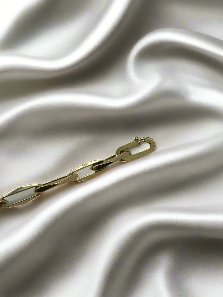 De vintage gouden armband 14k closed forever 10.2gr van Juwelier van der Kooij is gelegd op een gladde, witte satijnen stof, met zachte vouwen die een zachte textuur creëren die prachtig contrasteert met het glanzende oppervlak van de 14k gouden armband.