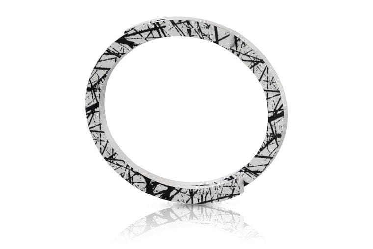 Witte armband met zwart abstract patroon en een strakke, gladde afwerking.