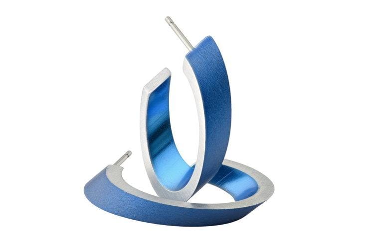 Ovale creolen in blauw met een glanzende afwerking en een zilveren rand.