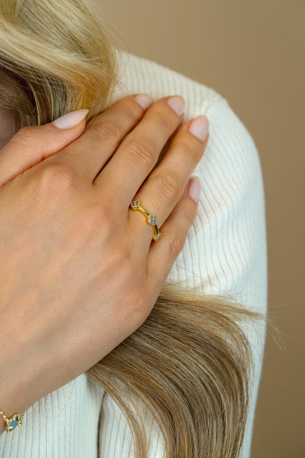 Gouden ring met een golvende vorm en drie kleine, glinsterende steentjes.