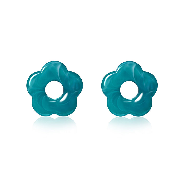 Een paar glanzende, gemarmerde turquoise bloemvorm Zinzi oorbedels (ZICH2720T) met een ronde uitsparing in het midden, weergegeven op een witte achtergrond - perfect om stijlvolle flair toe te voegen aan elke look.