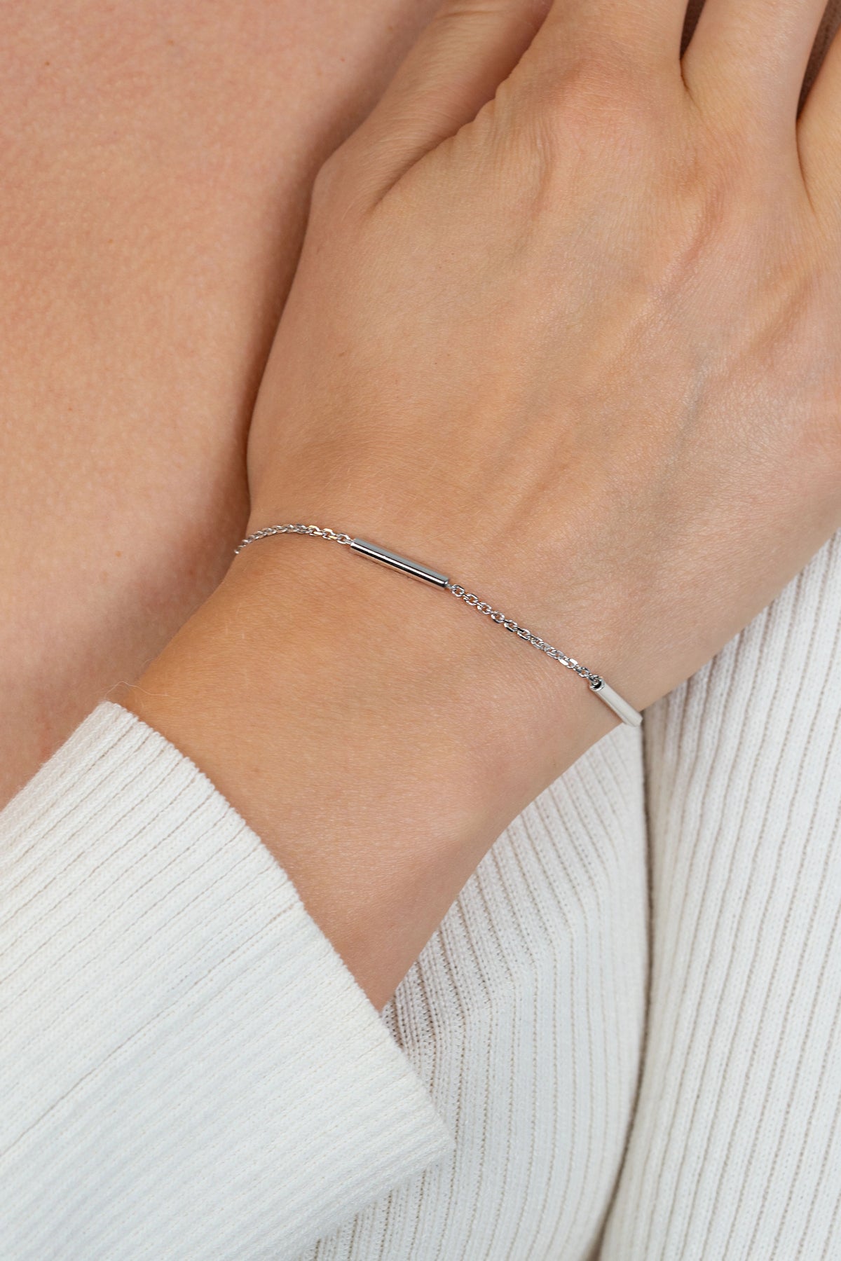 Zilveren schakelarmband met drie gladde ronde staafjes en een fijne ketting.