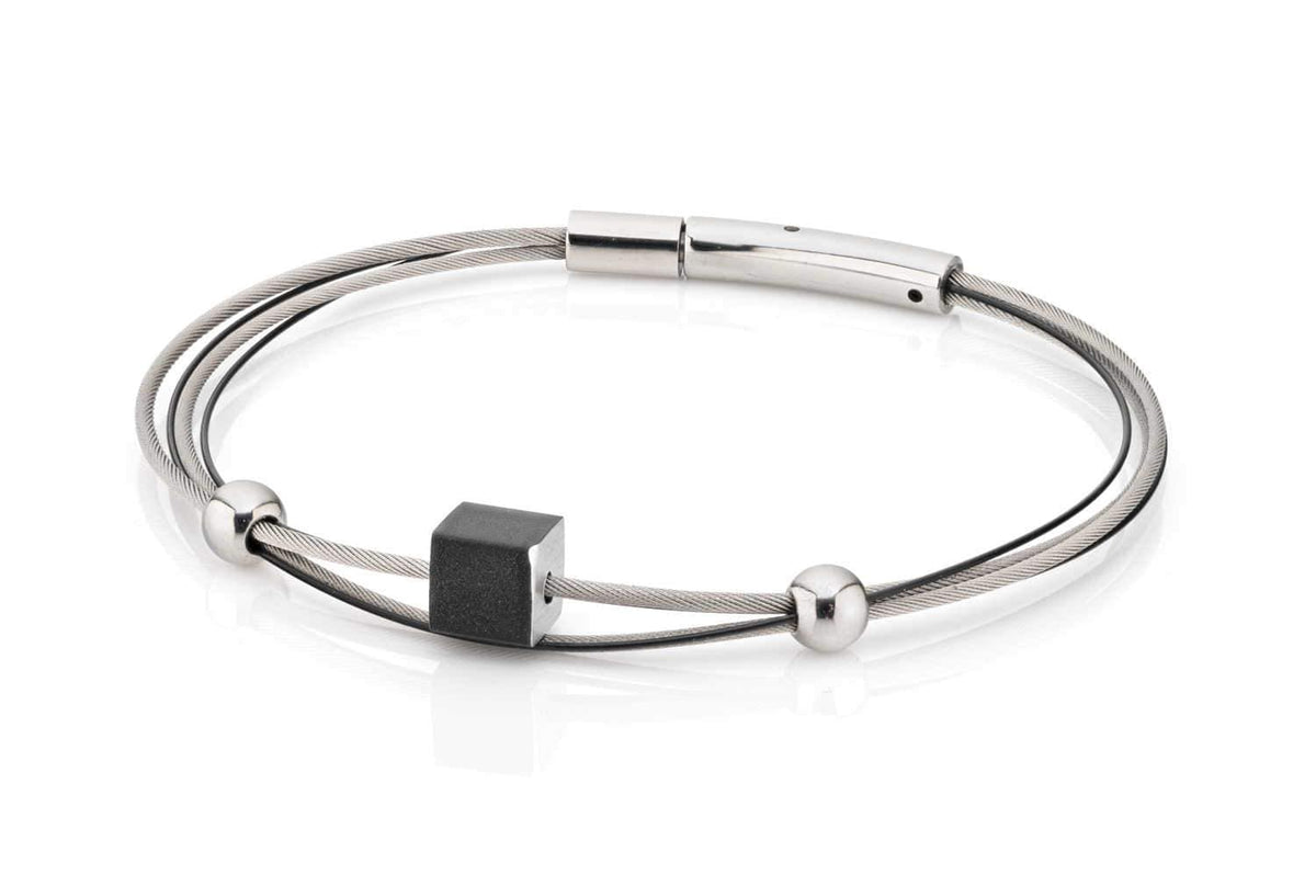 Zilveren armband met een zwart kubusje en twee ronde, glanzende elementen.