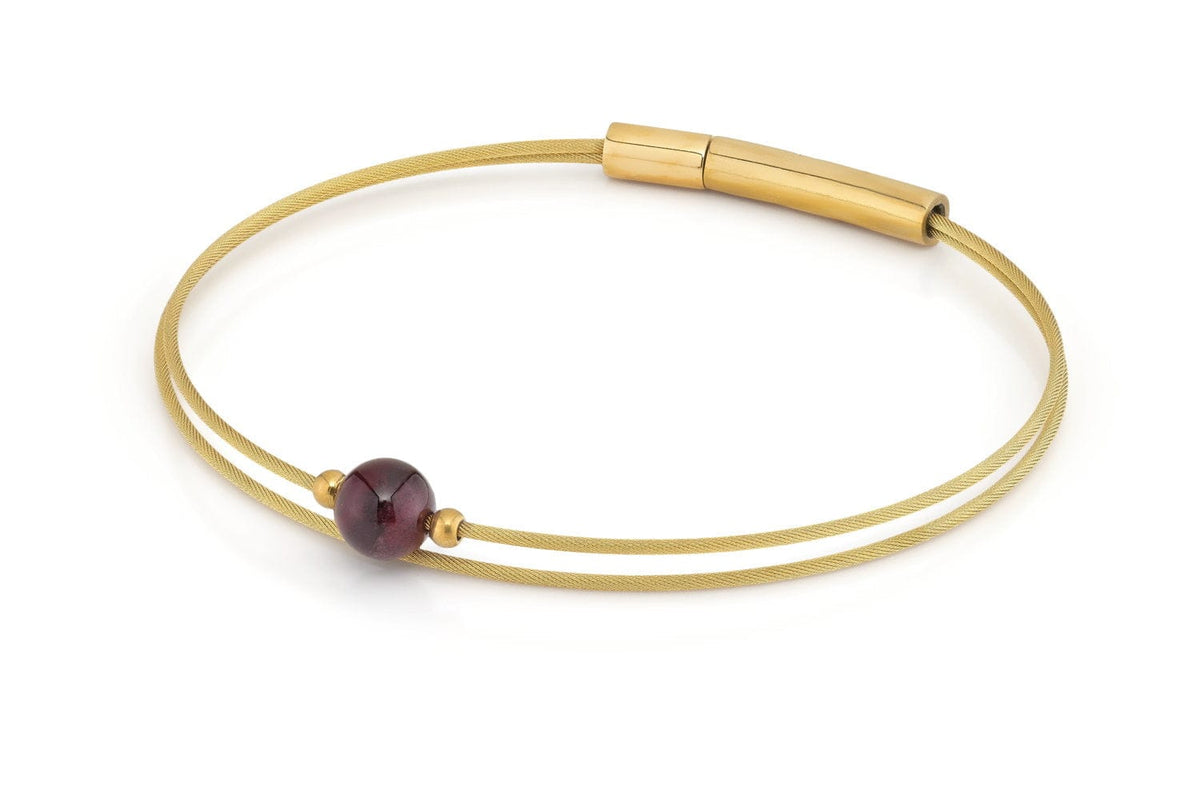 Goudkleurige armband met granaatsteen en een strakke, minimalistische uitstraling.