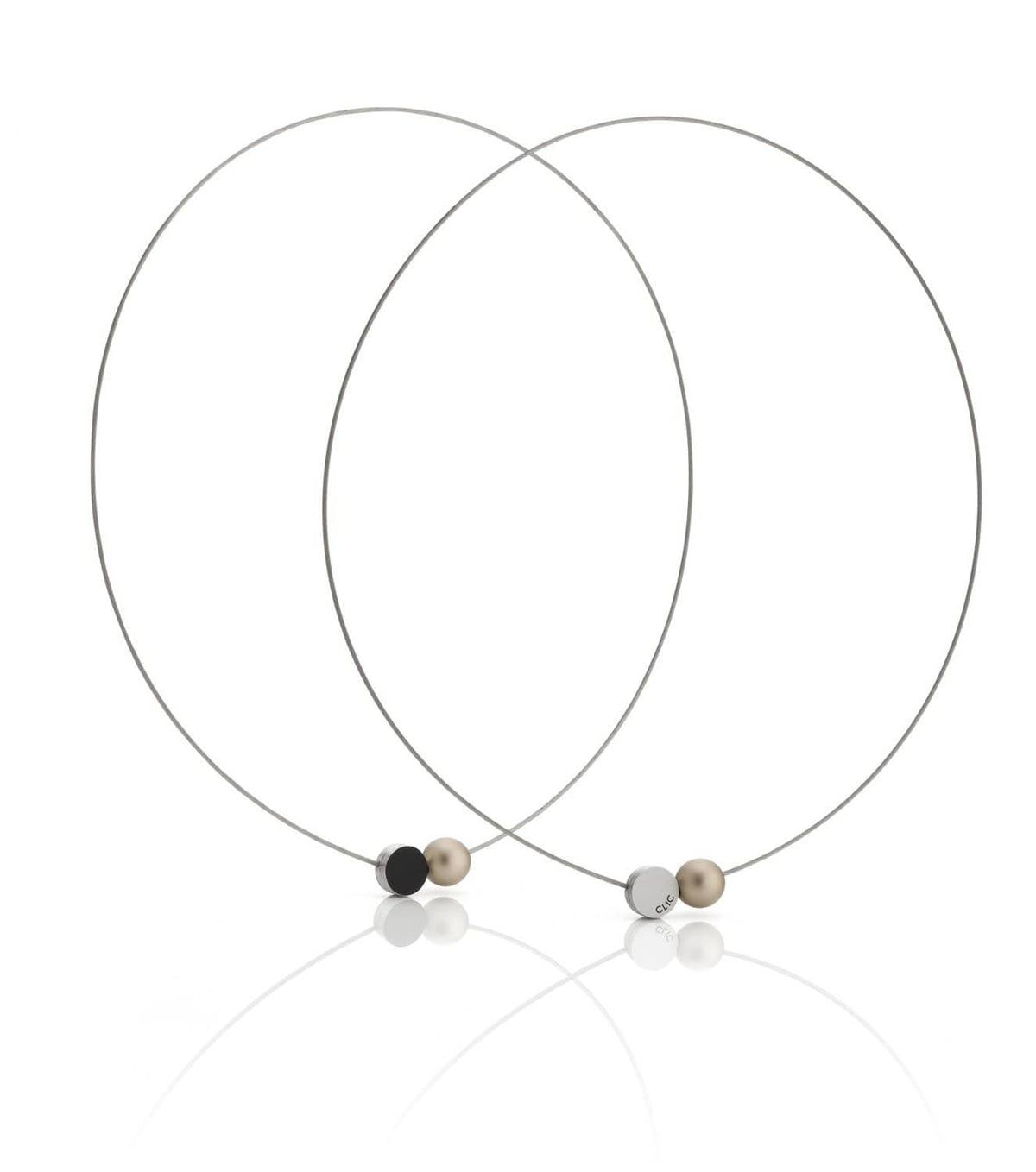 De Collier Mini Kogeltje Goud C192G van CLIC Creations bestaat uit twee dunne kettingen met kleine bolvormige kralen in zwart, beige en zilver en een magnetische sluiting. Ze zijn handgemaakt in Nederland en overlappen elegant met kralen die aan de voorkant op een reflecterend oppervlak zijn geplaatst.