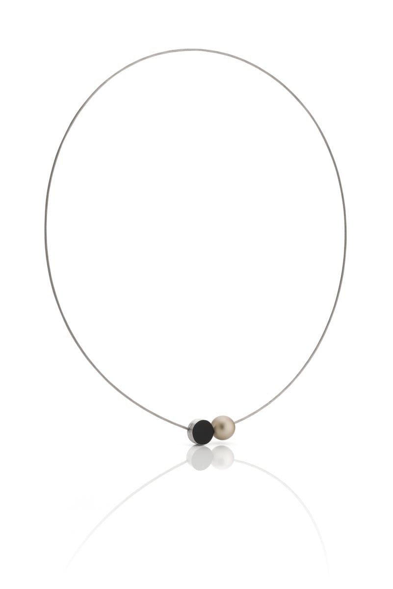 De Collier Mini Kogeltje Goud C192G van CLIC Creations is een minimalistische ketting met een dunne ronde draad met twee middelste kralen: een zwarte, platte, ovale en de andere rond en parelachtig. Handgemaakt in Nederland tegen een witte achtergrond.