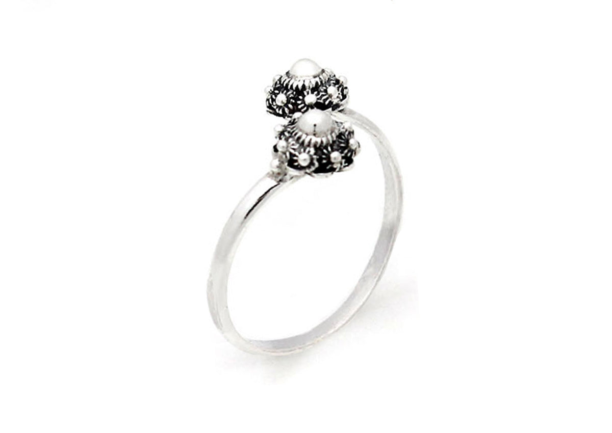 De Zeeuwse Knoop Ring Zilver nr6 van Dutch Button heeft een dunne zilveren band met twee sierlijke koepelvormige ontwerpen, versierd met ingewikkelde patronen en kleine bollen, tegen een effen witte achtergrond.