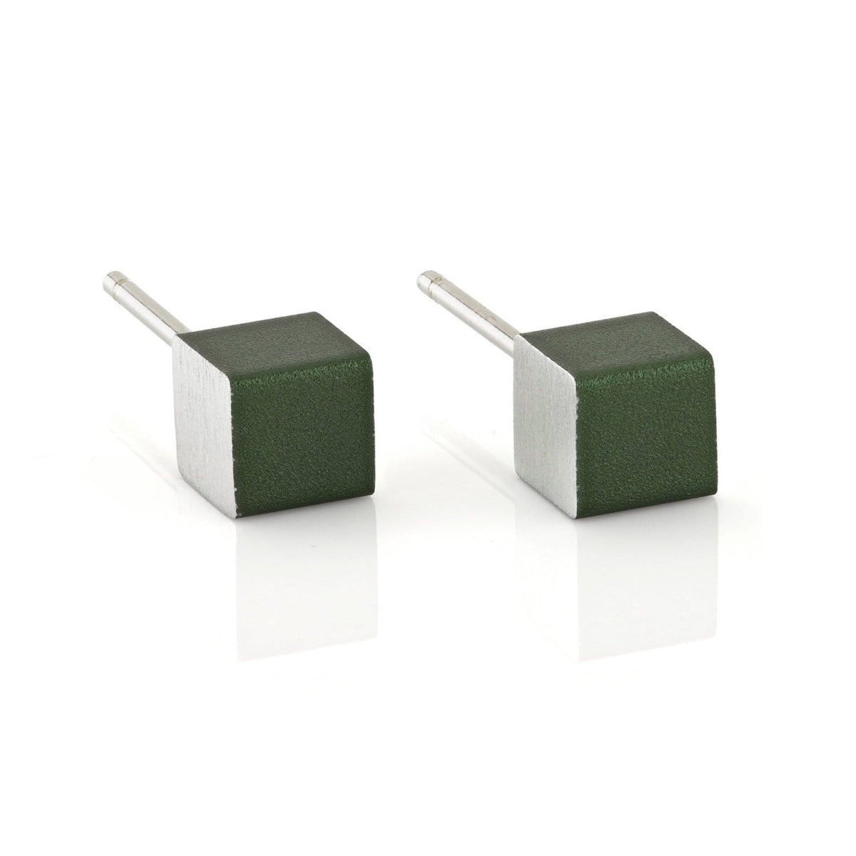 De Oorsieraad Kubusjes Groen O28GR van CLIC Creations zijn kubusvormige zilveren oorbellen met donkergroene vlakken, elegant rustend op een wit reflecterend oppervlak. Handgemaakt in Nederland en hypo-allergisch, ze tonen uniek vakmanschap en stijl.