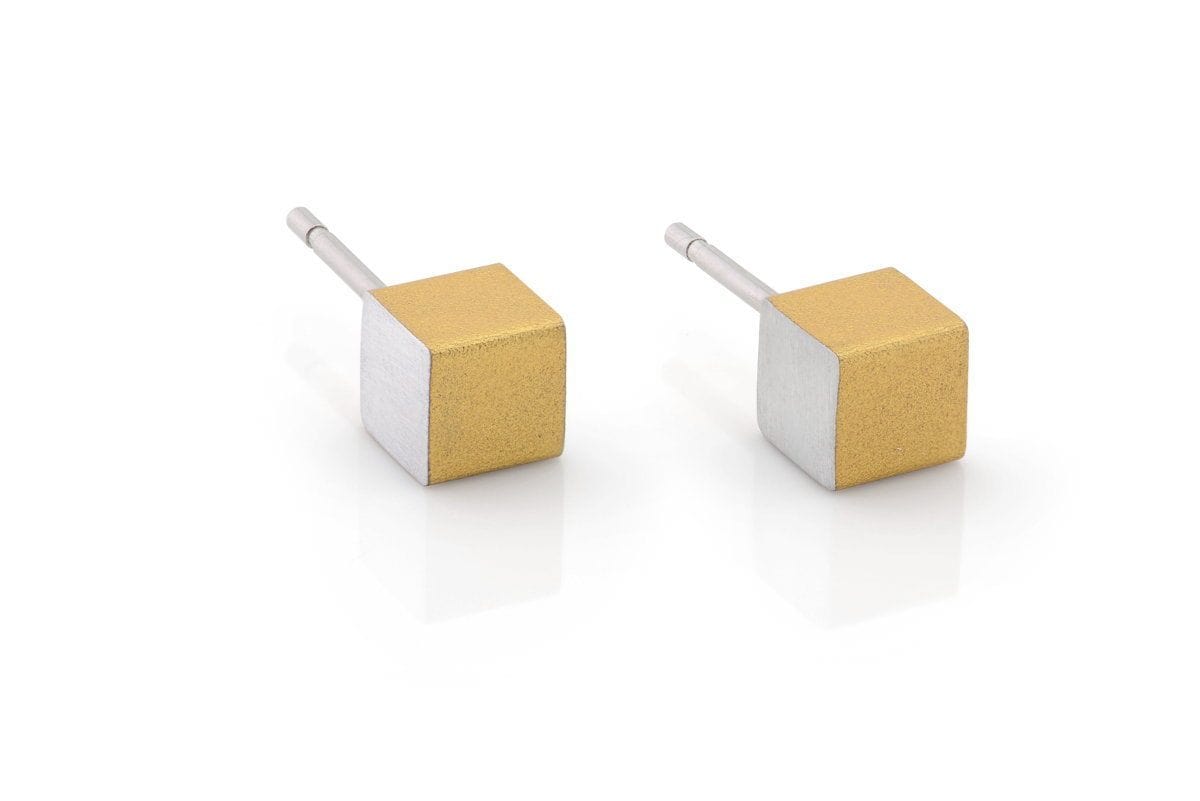 Goudkleurige oorsieraden in de vorm van kubusjes met een zilverkleurige basis.