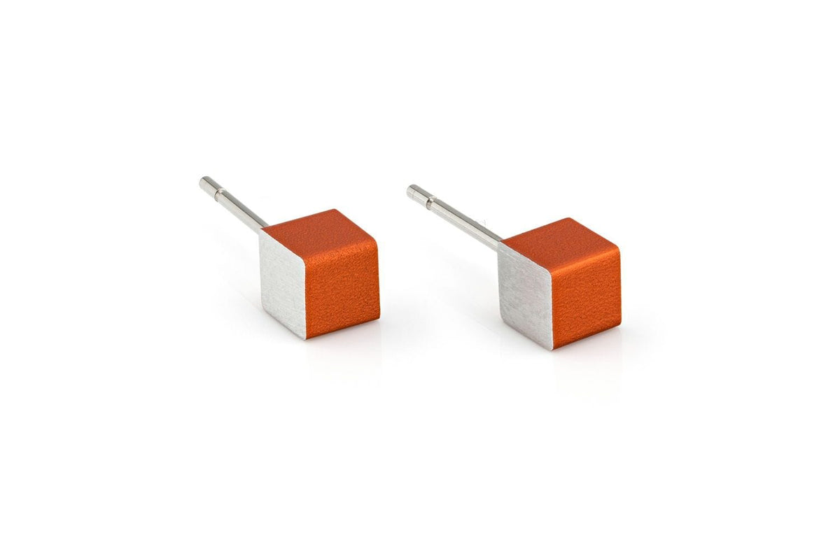 Clic Creations Oorsieraad Kubusjes Oranje O28O: handgemaakte, hypo-allergene oorbellen met kubusvormige designs-twee oranje en vier zilveren zijden-op een witte achtergrond. Perfect voor gevoelige oren.