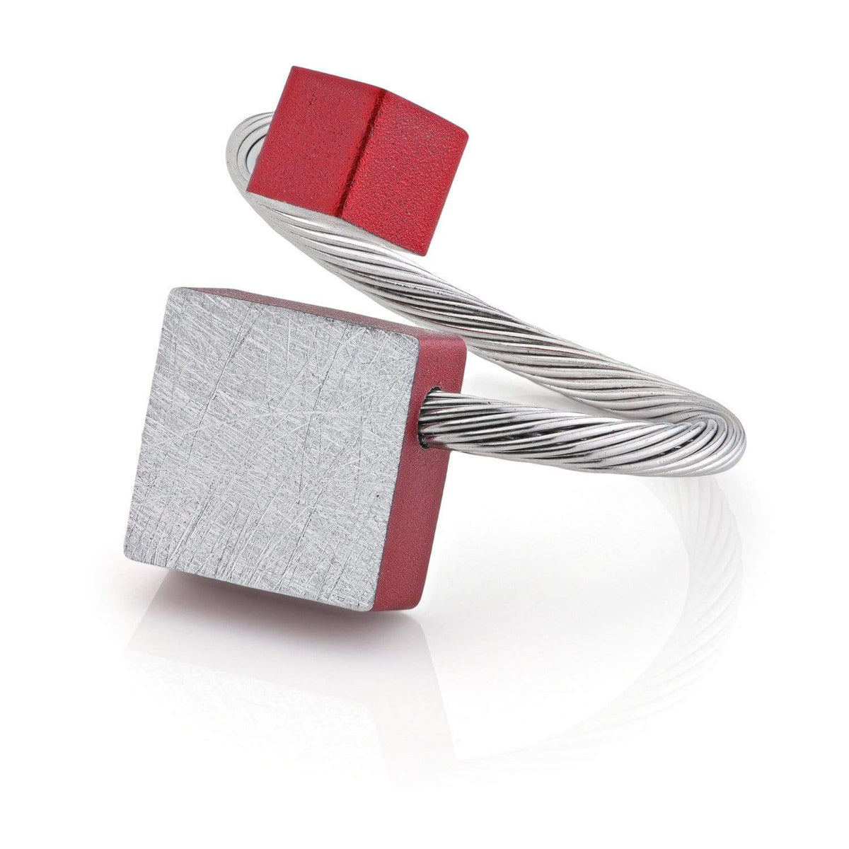 Ring met een vierkante zilveren schijf en een rood kubusje op een flexibele draadband.
