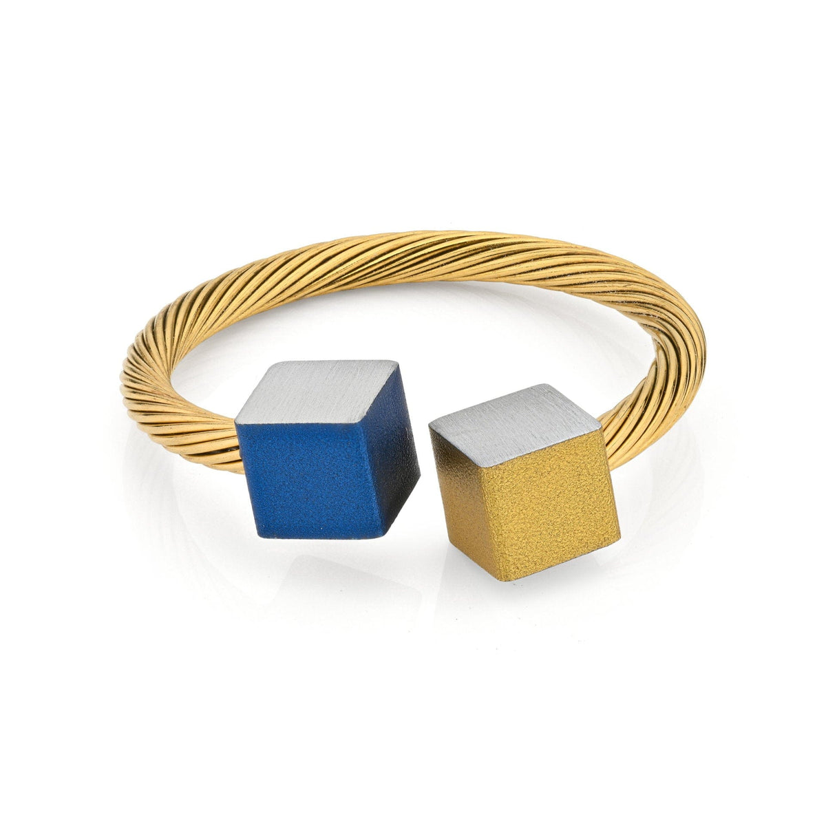 Goudkleurige ring met twee kubusjes, één blauw en één goudkleurig, op een gedraaide band.