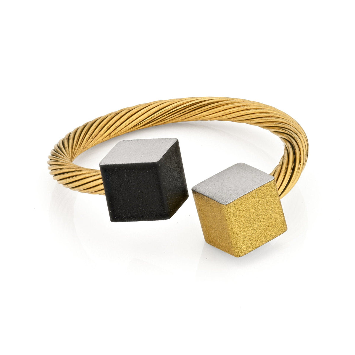 Goudkleurige ring met gedraaide band en twee kubusjes in zwart en goudkleurig.