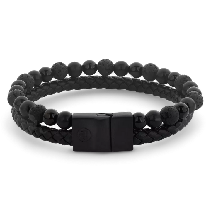 De Rebel & Rose Full Metal Combo 12mm Black Rocks heren kralen armband combineert ronde zwarte kralen, sommige met een ruwe textuur, met een zwarte leren band en een matte edelstalen sluiting voor een stijlvolle look.