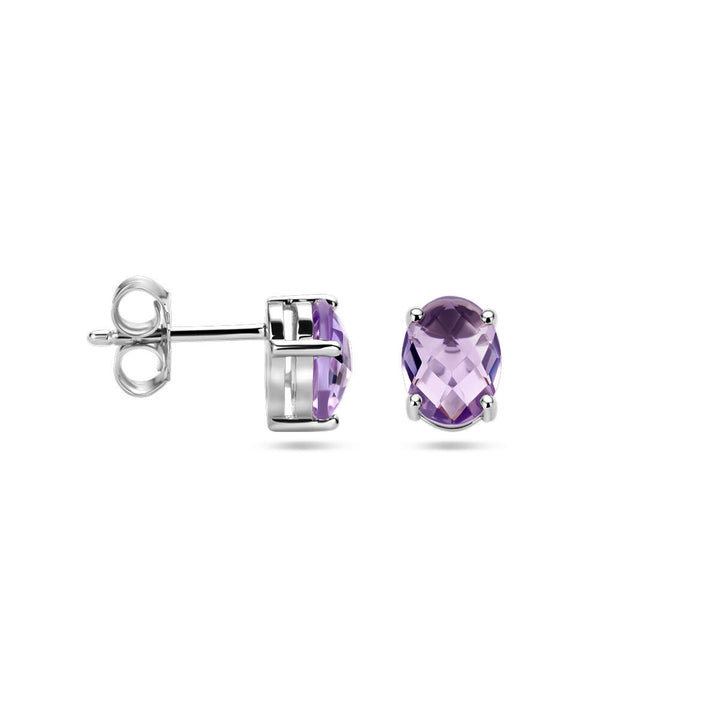 Een paar oorknoppen amethist zilver gerhodineerd van Van der Kooij Collectie, met ovaal geslepen facetgeslepen paarse edelstenen, afgebeeld op een witte achtergrond met één oorbel van de zijkant en de andere van de voorkant.