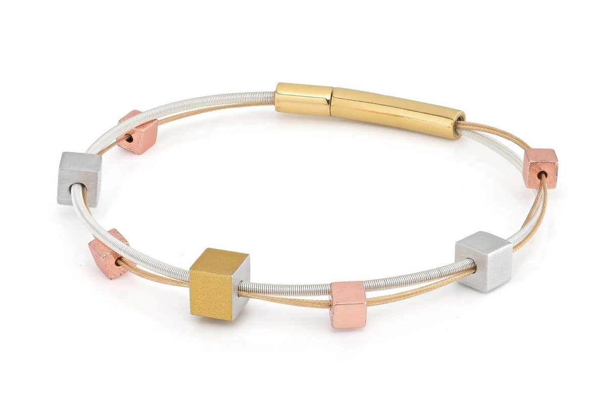 Armband met speelse tricolor kubusjes in goud, zilver en roségoud op een flexibele band.