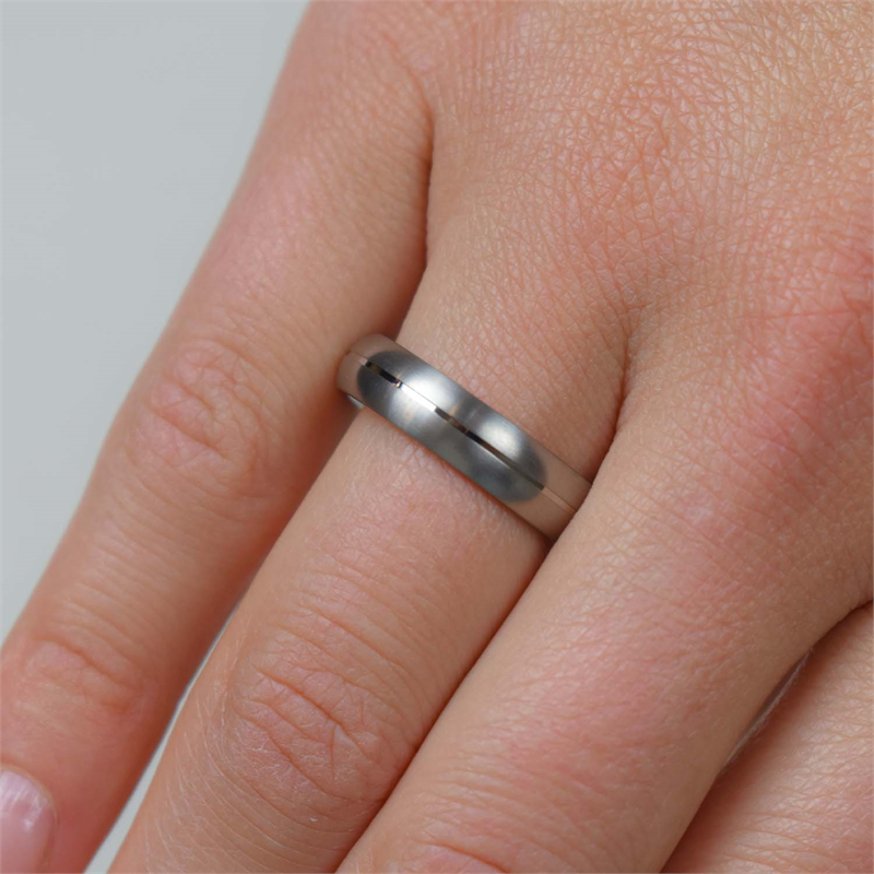 Een close-up van een hand die de Boccia Titanium Ring 0130-01 van Boccia draagt aan de ringvinger tegen een lichte achtergrond.