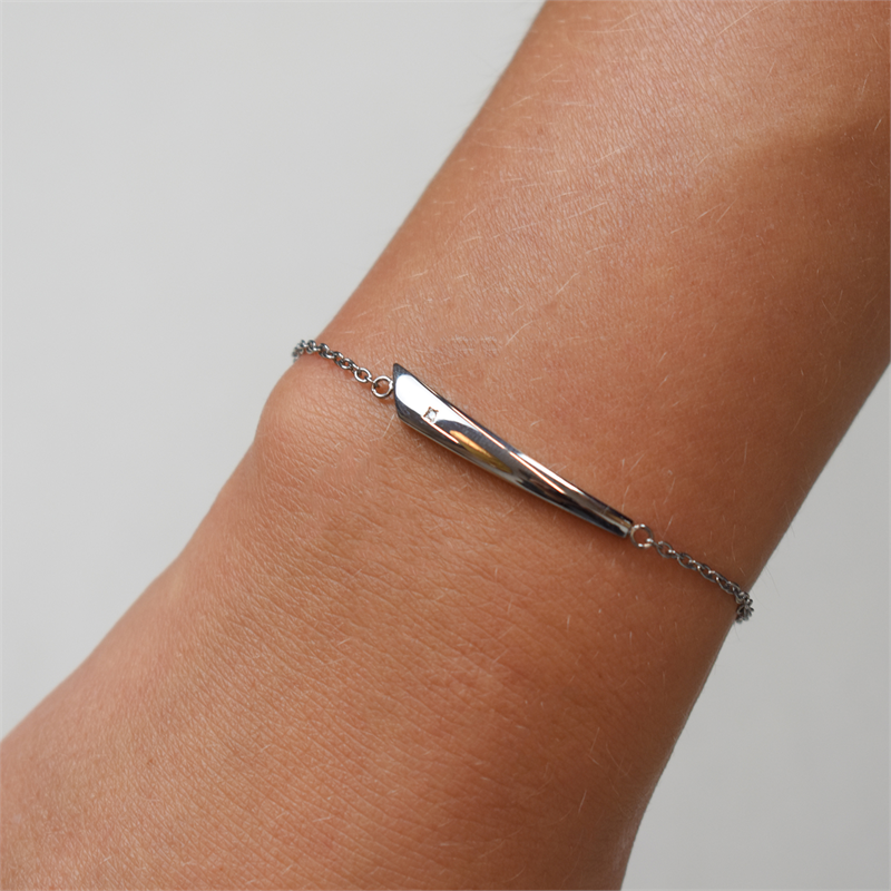 Een close-up van een pols die de Boccia Titanium Armband dia 1/0.005 - 03038-03 draagt, een delicate zilveren damesarmband van Boccia met een slank, gepolijst metalen middenstuk, tegen een neutrale achtergrond.
