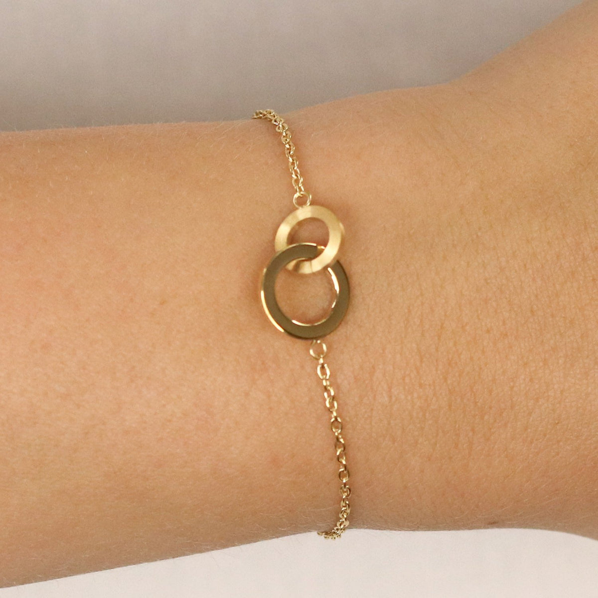 De Boccia Titanium Armband gp 03029-03 van Boccia heeft een delicate, dunne goudkleurige ketting met twee in elkaar grijpende ringen, wat een eenvoudig en elegant ontwerp creëert dat perfect is voor de pols.