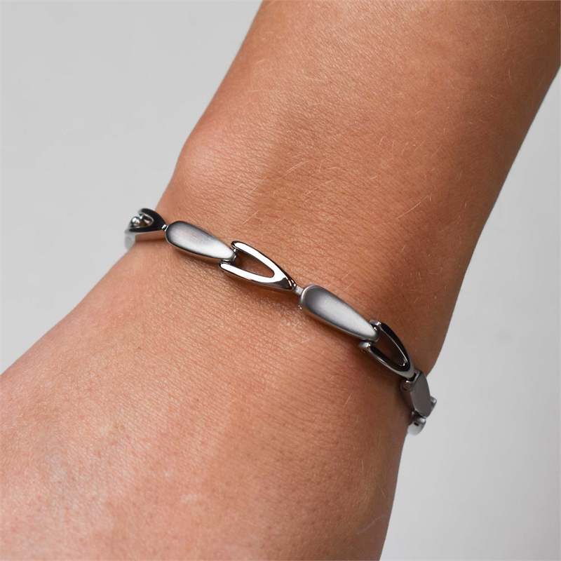 Een close-up van een pols met de Boccia Titanium Armband NL 03033-01, met strakke, zilverkleurige, langwerpige ovale schakels tegen een effen, lichte achtergrond.