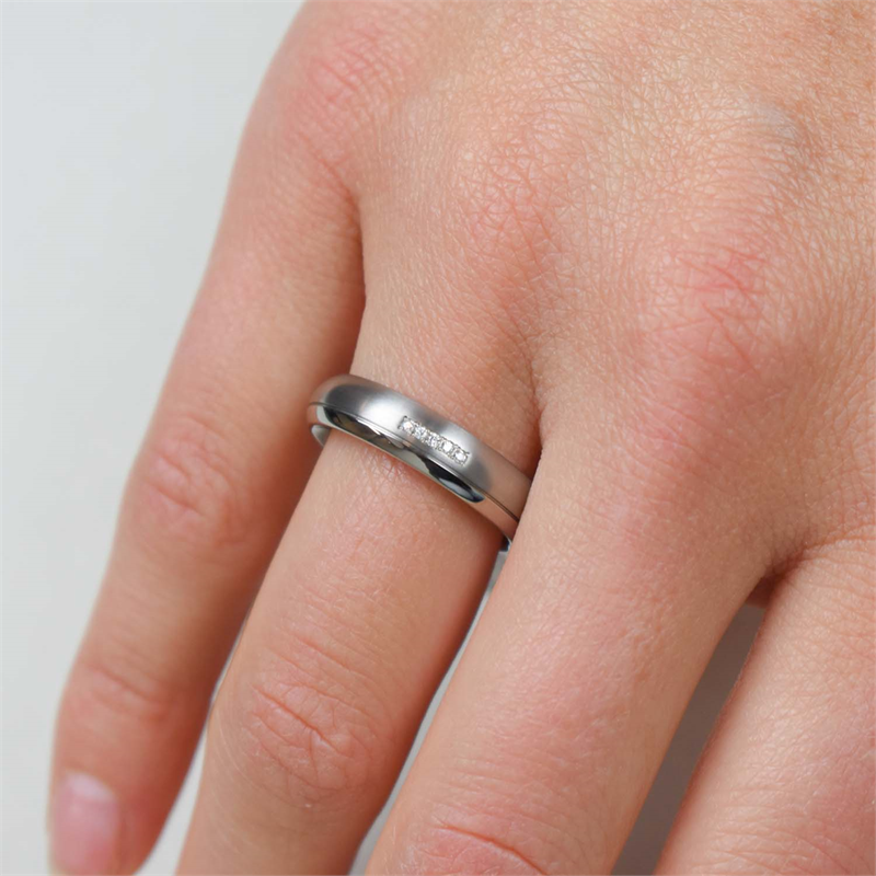 Een close-up toont een blanke hand die de Boccia Titanium Ring dia 5/0.025 - 0130-09 aan de ringvinger draagt tegen een effen, lichtgekleurde achtergrond.