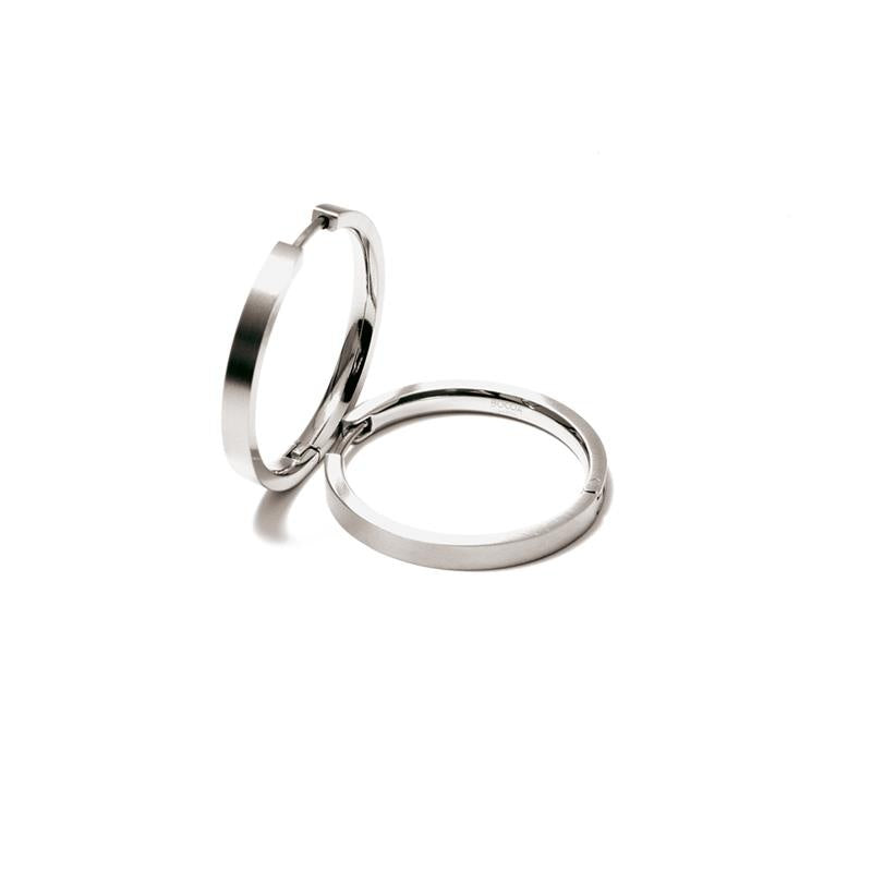 De Boccia Titanium Oorringen 0517-01 van Boccia worden weergegeven op een witte achtergrond, waarbij de ene zilverkleurige oorring rechtop staat en de andere plat, licht overlappend.
