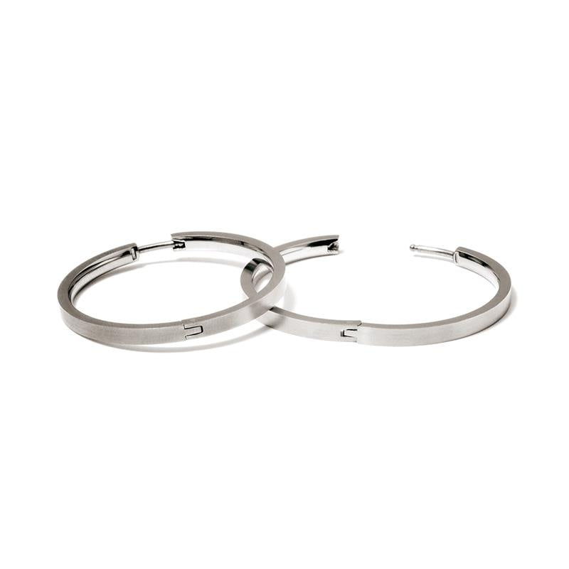 Een paar Boccia Titanium Oorringen 0516-01 van Boccia, met een minimalistisch zilverkleurig ontwerp en gladde afwerking in duurzaam materiaal, worden overlappend getoond op een witte achtergrond.