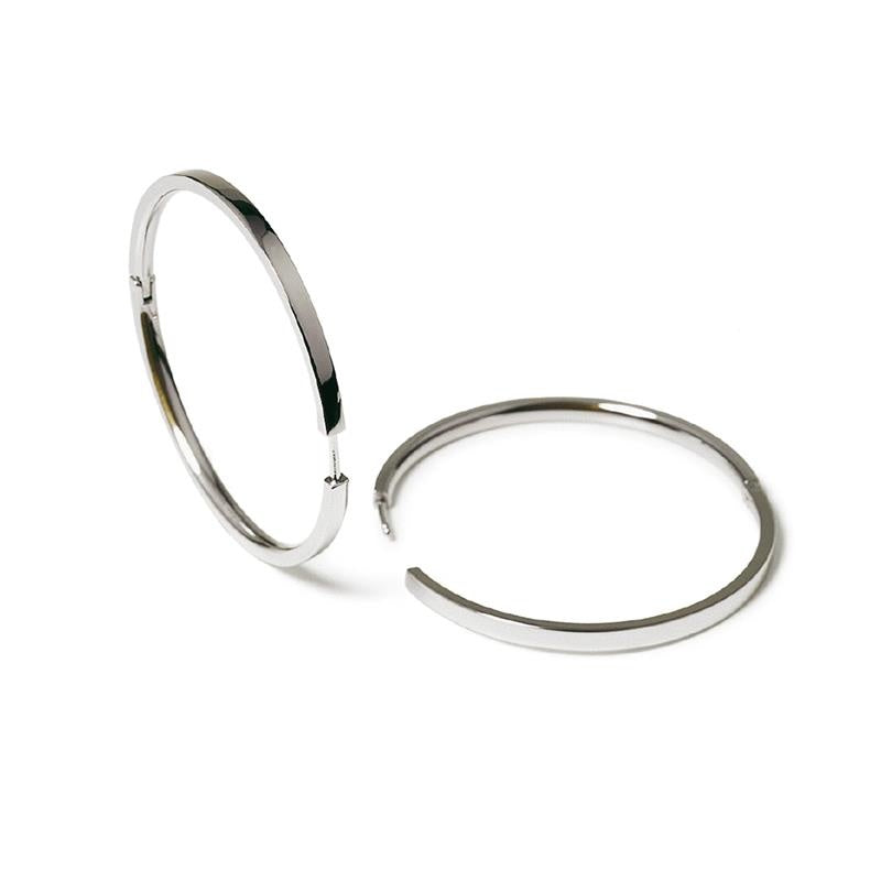 Twee grote, glanzende Boccia Titanium Oorringen 0508-03 worden getoond op een witte achtergrond. De ene staat rechtop en de andere ligt plat, beide benadrukken een eenvoudig, minimalistisch ontwerp van Boccia.