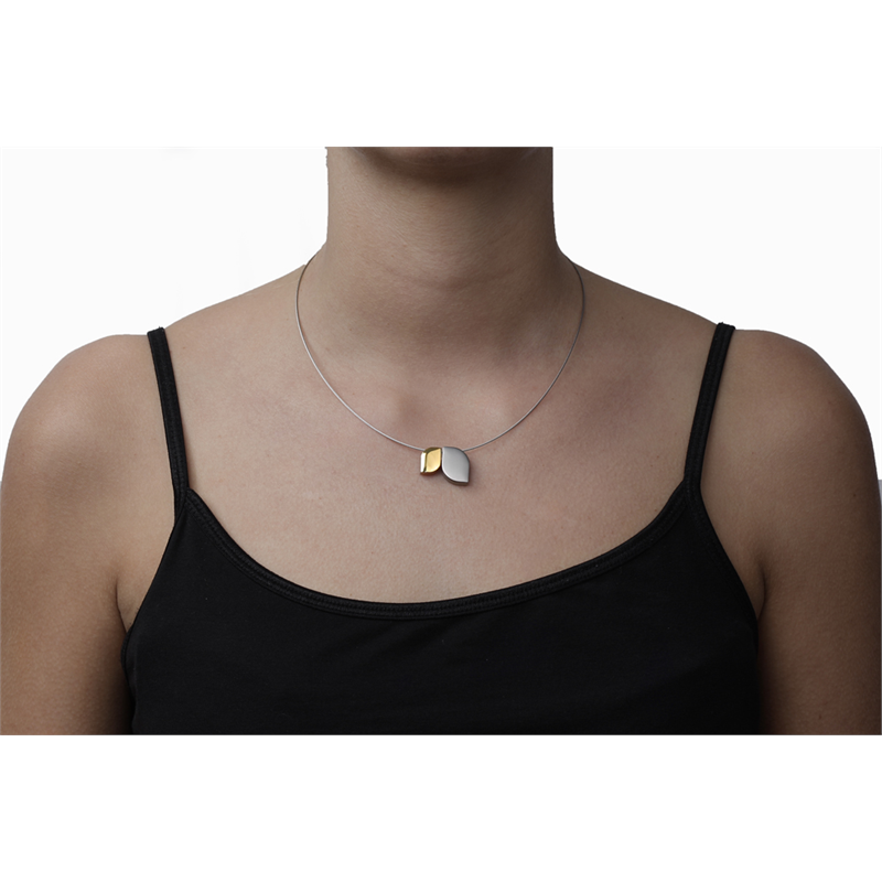 Een vrouw draagt de Boccia Titanium Hanger Bicolor 07009-01 ketting – een dunne zilveren ketting met een hanger van goud en zilver – over een zwarte top met spaghettibandjes tegen een witte achtergrond.