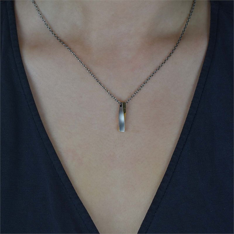 De Boccia Titanium Hanger Bicolor 07018-02 ketting, met zijn minimalistische maar strakke rechthoekige hanger, valt elegant om iemands nek en steekt prachtig af bij een donker topje met V-hals.