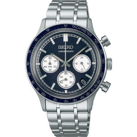 Zilveren chronograaf horloge met blauwe wijzerplaat, witte subdials en tachymeter.