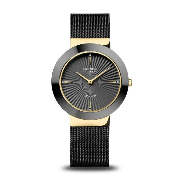 Gouden dameshorloge met keramische kast, zwarte mesh-band en diamantdetails op de wijzerplaat.