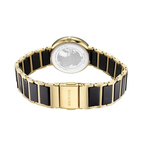 Een Bering dames horloge (model 11429-732) uit de keramische collectie, met een gouden en zwart metalen schakelband met slanke zwarte rechthoekige accenten, getoond vanaf de achterkant om de gegraveerde achterkant van de kast en de sluiting met Bering-logo te laten zien.