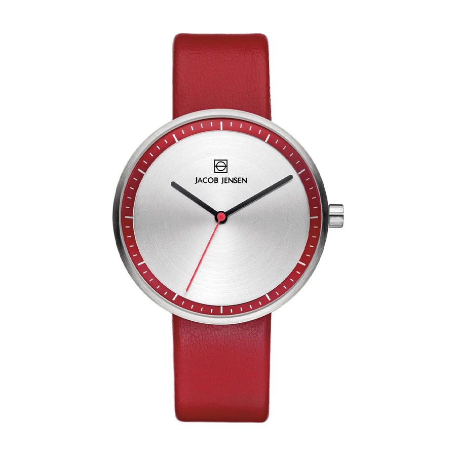Zilveren horloge met een rode leren band en een minimalistische wijzerplaat met rode accenten.